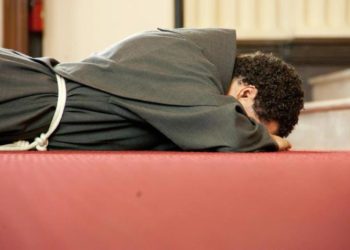 frate disteso a terra per la professione