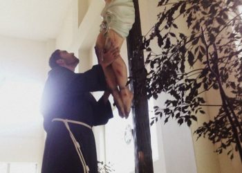 Frate abbraccia crocifisso