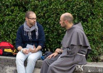 frate parla con un giovane ad Assisi